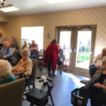 residents of a senior living community gathering around to participate in an activity
