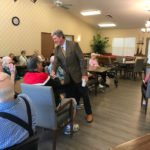 a man engaging in an activity with the residents of a senior living community