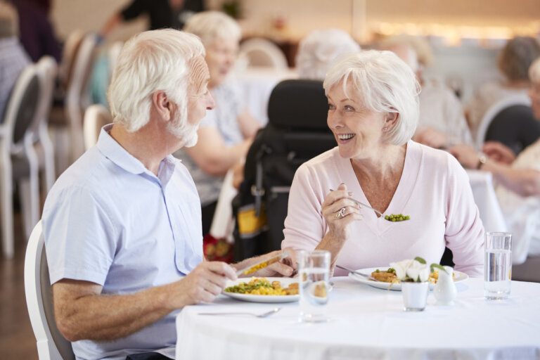 Male and female senior living residents enjoying a meal in the Park Place Senior Living community dining room