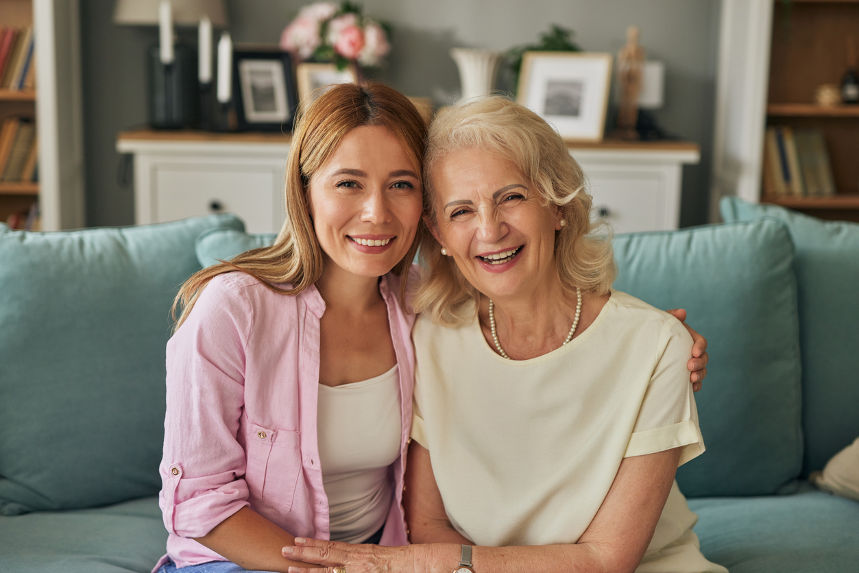 Female resident at Park Place Senior Living sitting on a couch in her apartment with her daughter